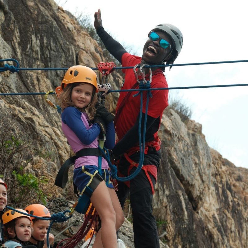 A camper on the Tyrolean traverse at Camp APA